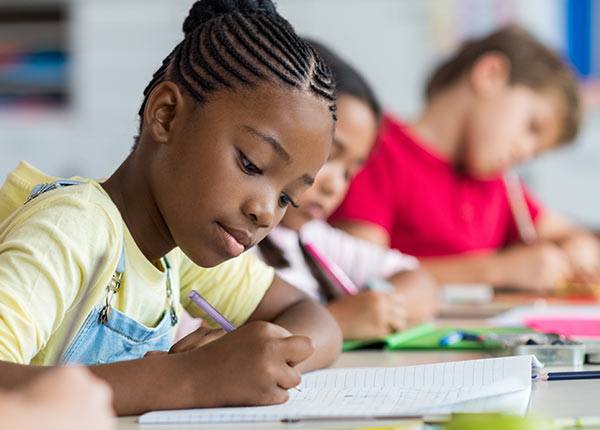 school age girl doing classwork at a desk