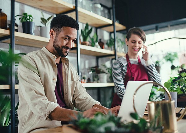 man working on laptop in floral shop