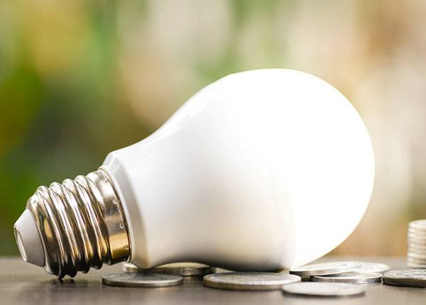 lightbulb laying on its side on a table with coins