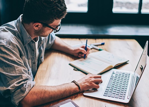 man with notebook and laptop